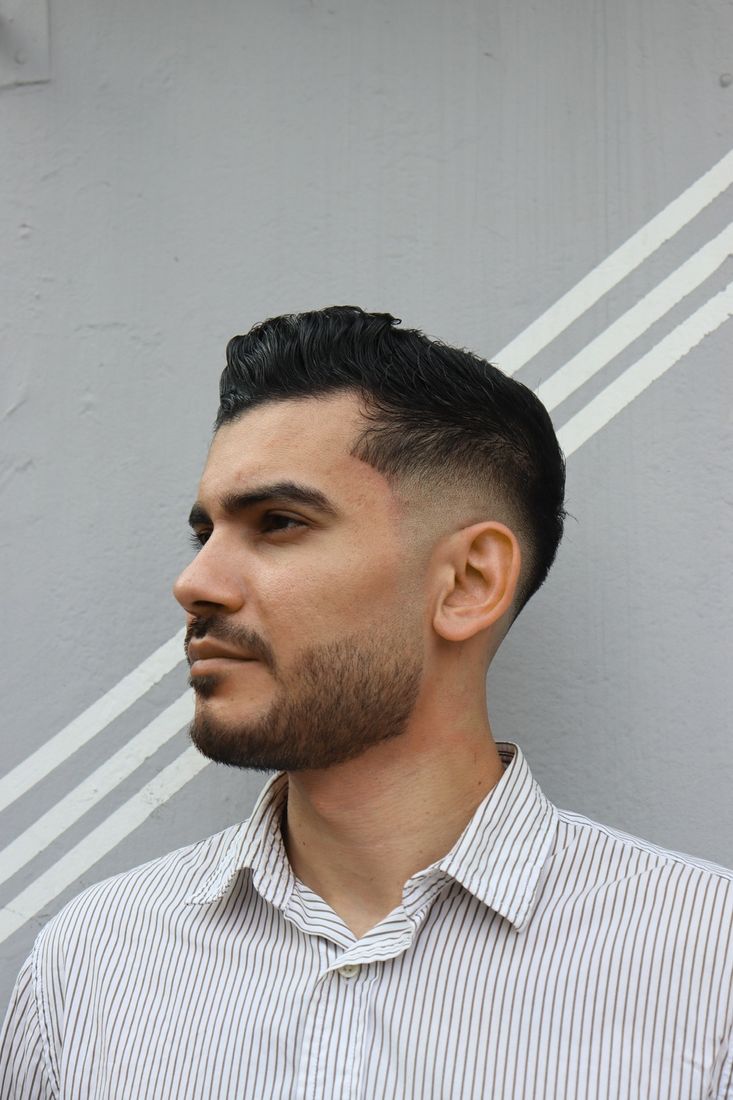 Corte con desvanecido alto y barba perfilada, vista tres cuartos.