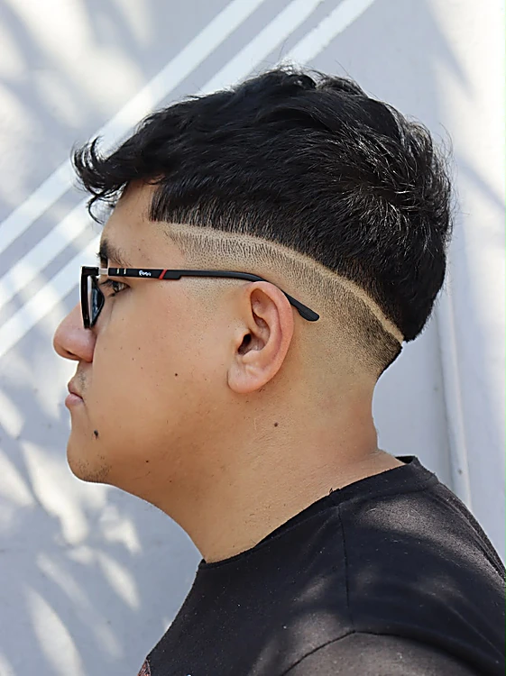 Perfil de un cliente con lentes: desvanecido bajo y raya diagonal trazada a navaja.